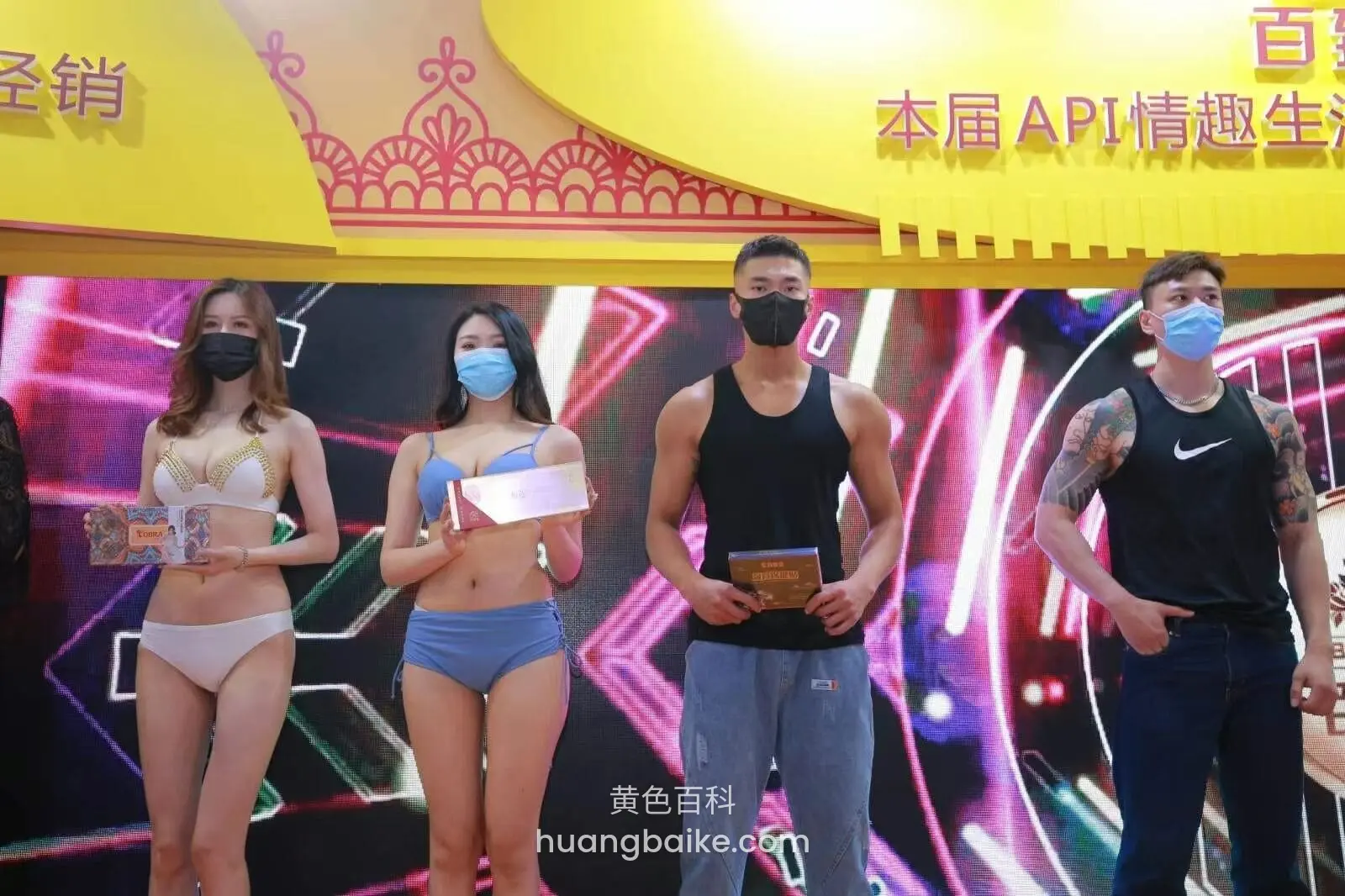 舞台上四人并排站着,手里拿着各自的奖牌和证书