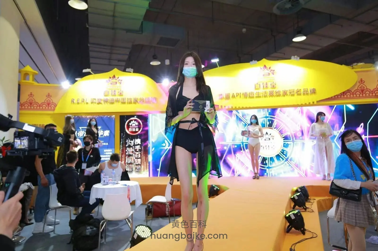 舞台中央走秀拿着话筒,镜头对着前方大屏幕和观众
