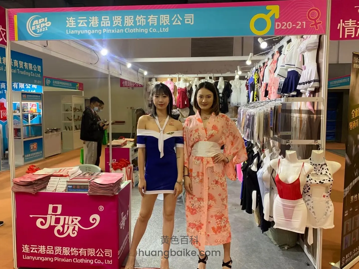 服装展位前站着看镜头,身后挂满各式情趣内衣