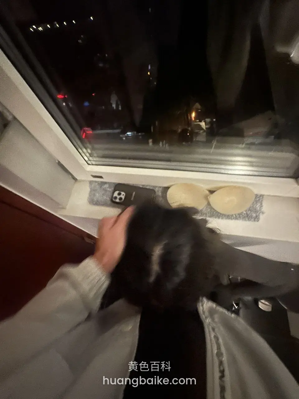 窗台放着硅胶胸垫和手机，低头看窗外夜景