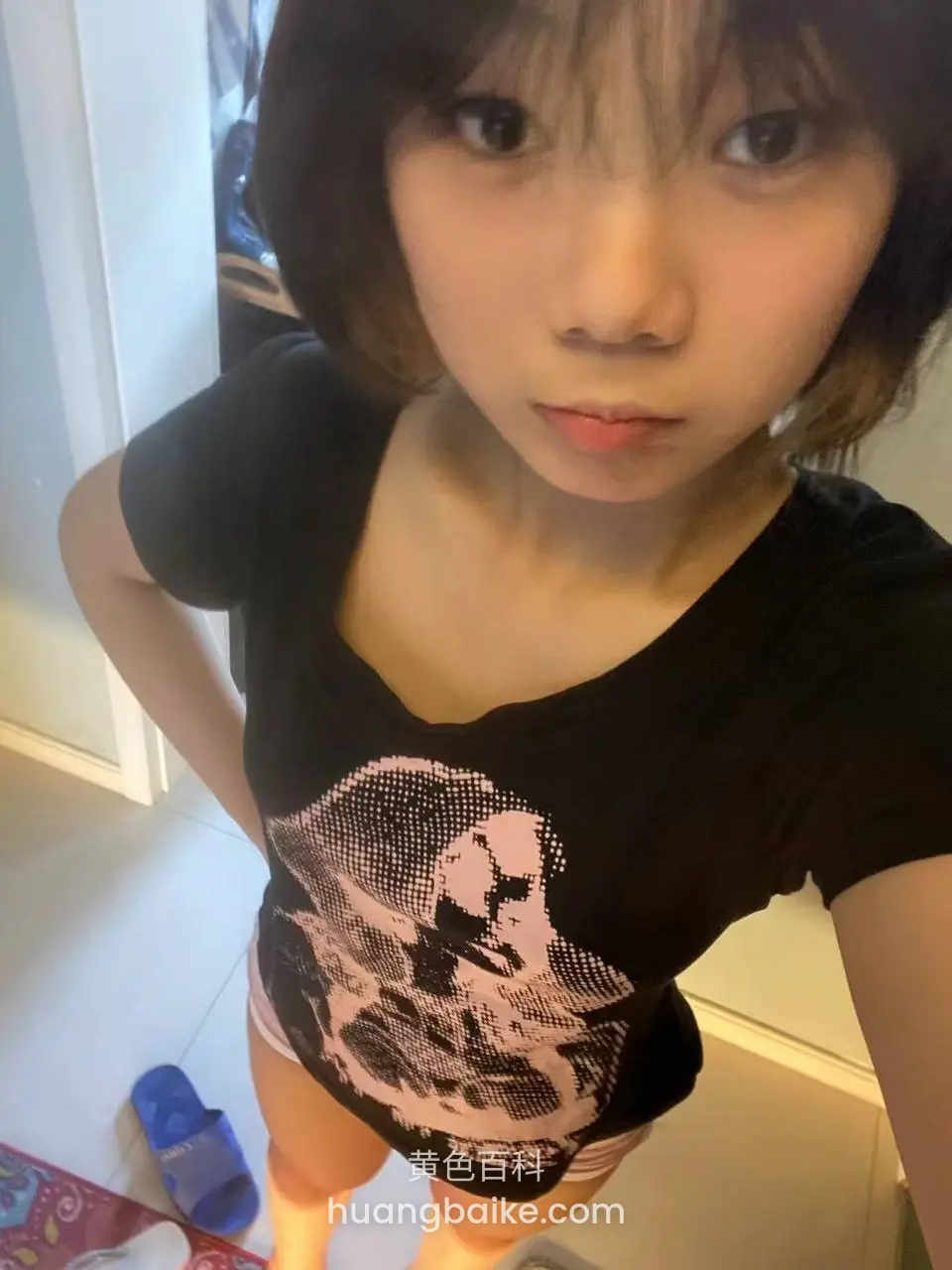 低角度仰拍穿黑T恤，左手叉腰