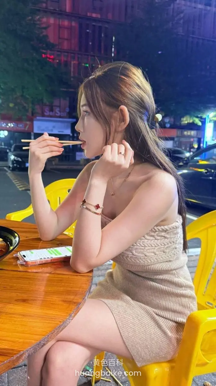 路边夜市摊吃东西，桌上手机