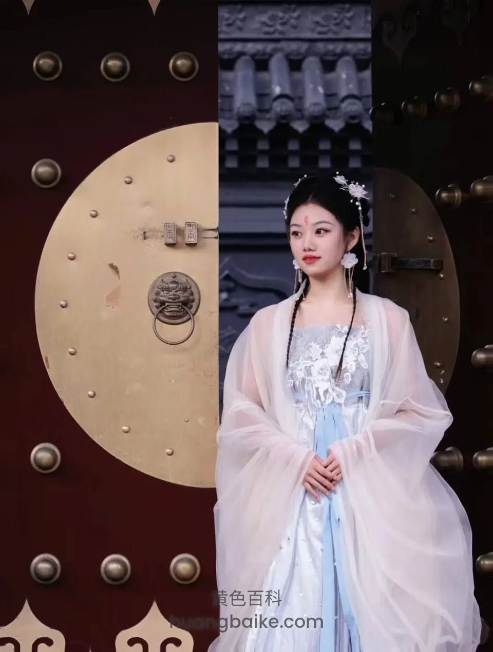 古典大门前站立，手扣在身前