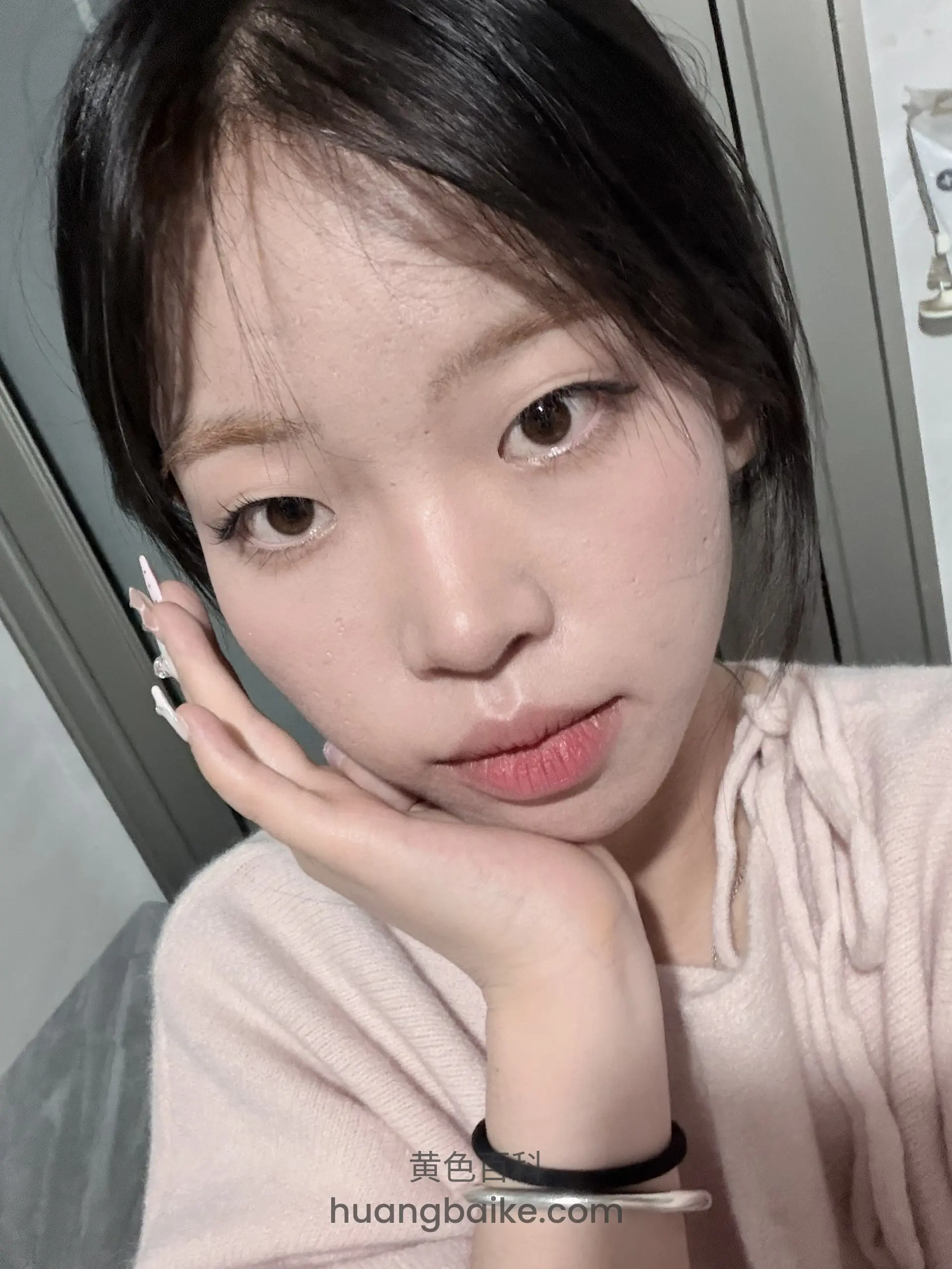 手托下巴贴近镜头，墙上有挂钩