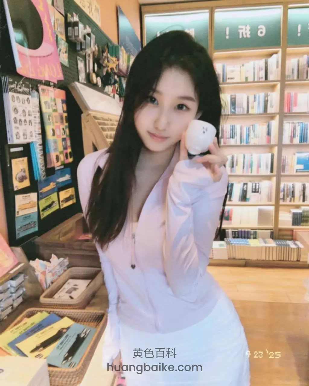 书店里对着镜头举起白杯子