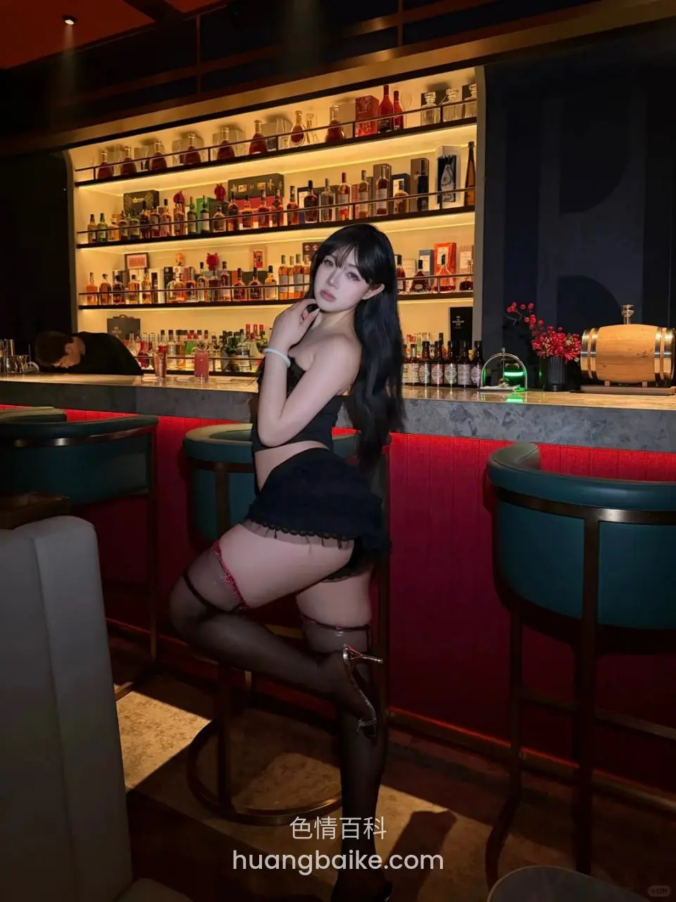 酒吧吧台前抬腿站着，身后一整排酒架