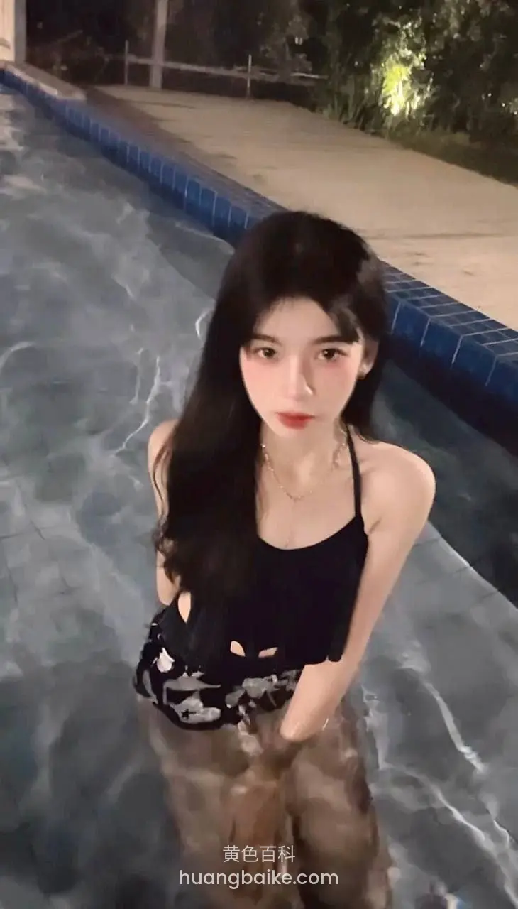 游泳池里站着低头看镜头