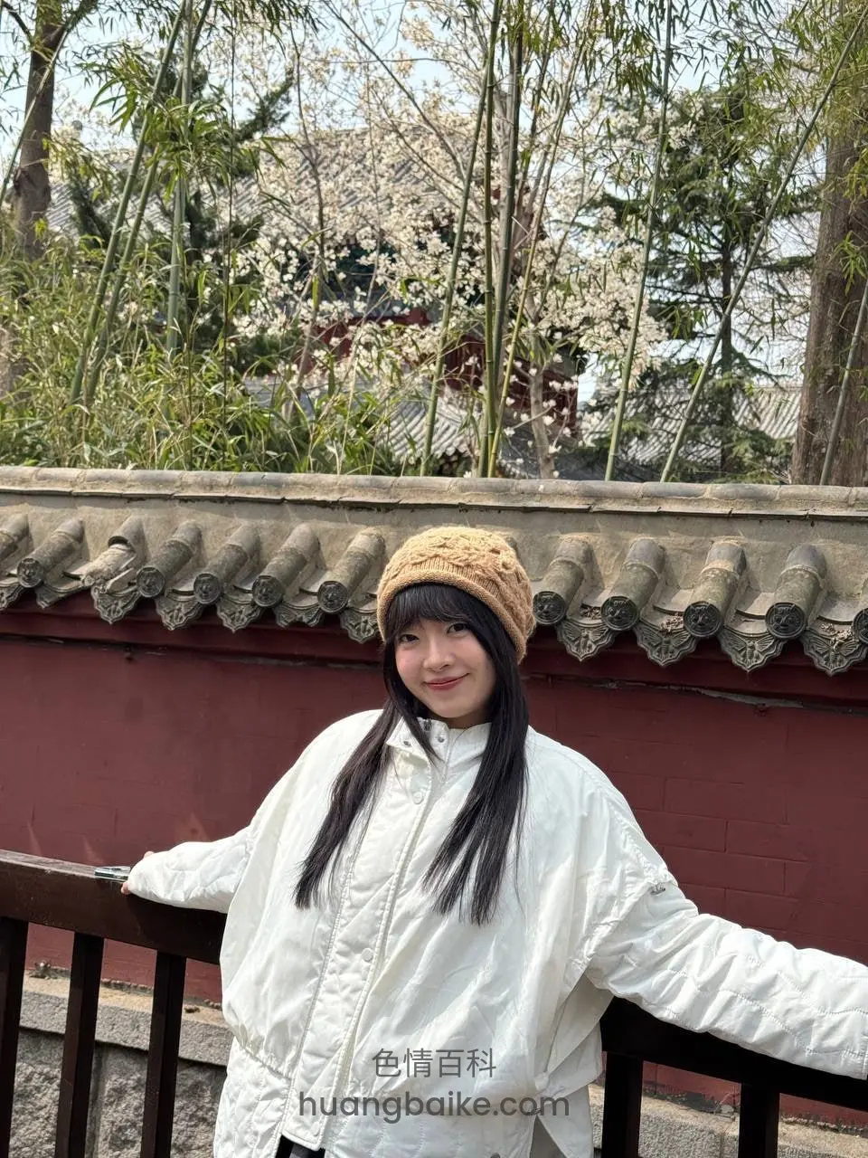 竹林红墙前，双手扶栏杆