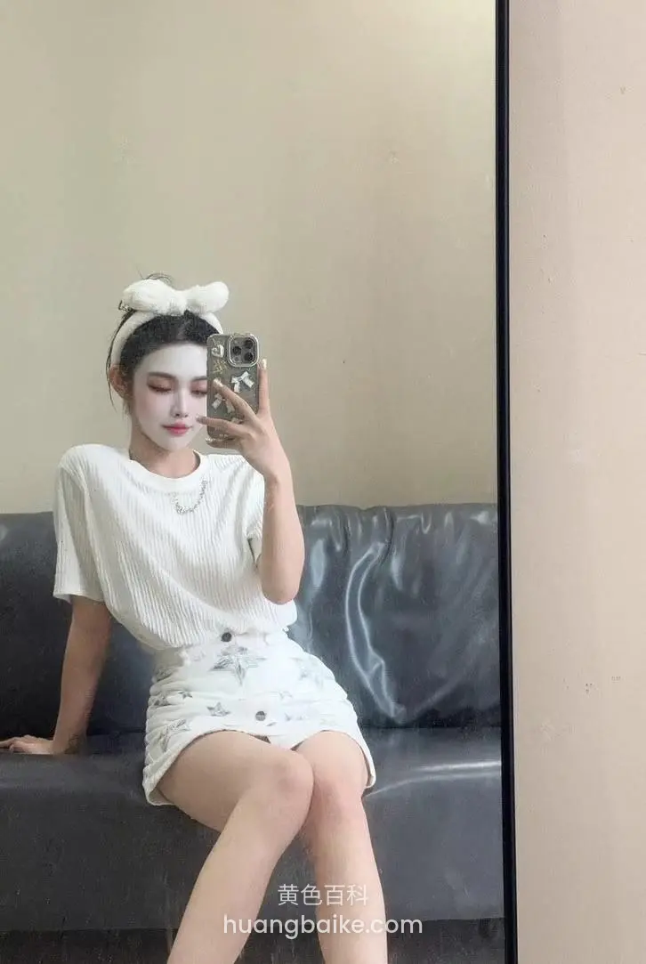 沙发上拿着手机自拍身后是黑色沙发