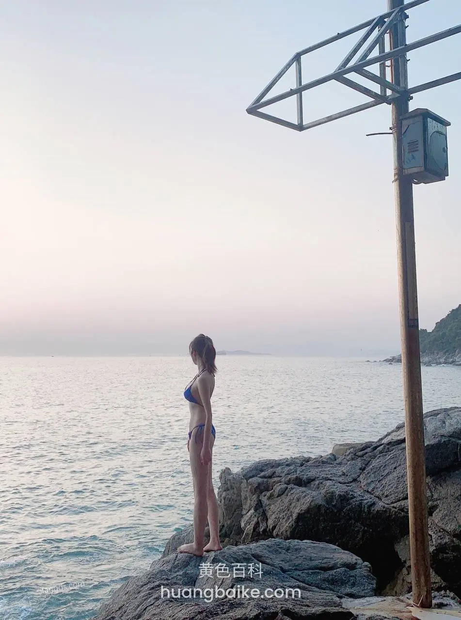 海边礁石上站着眺望大海