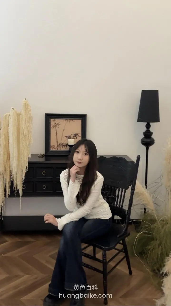 坐在黑椅子上手托下巴
