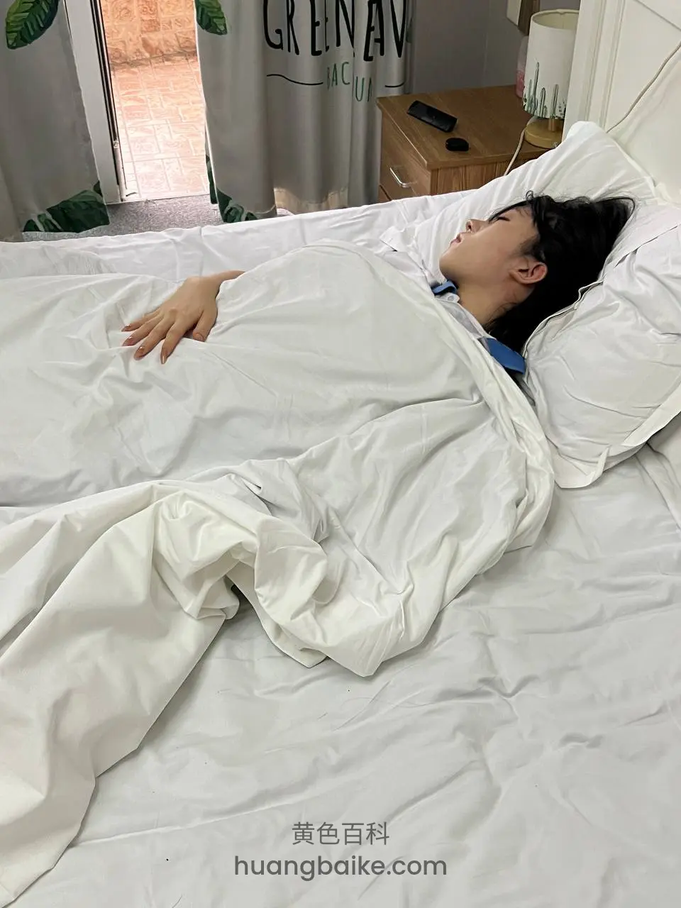 床上侧躺盖被，窗帘上有Green AV