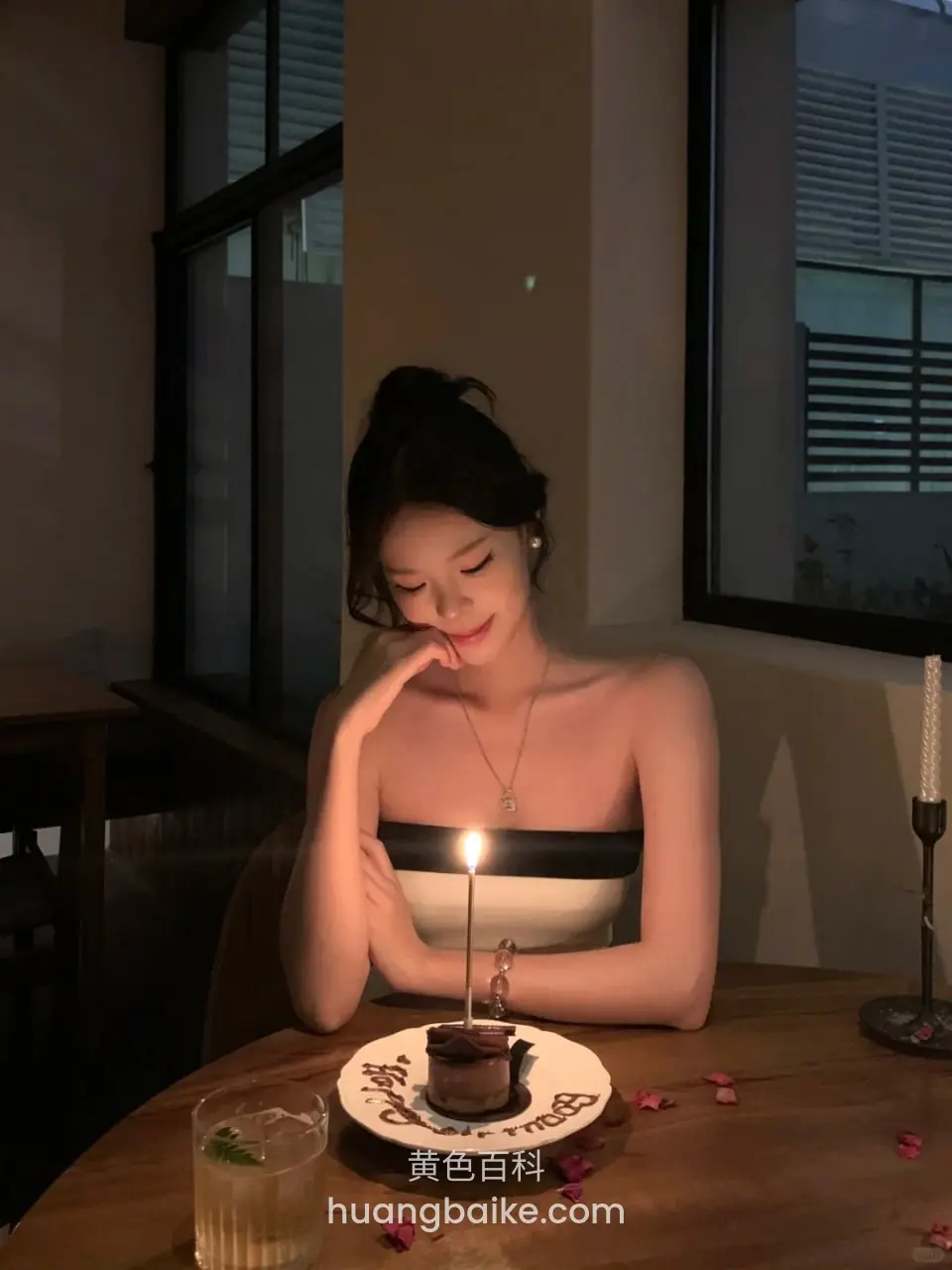 圆桌前托着下巴，看向蛋糕蜡烛