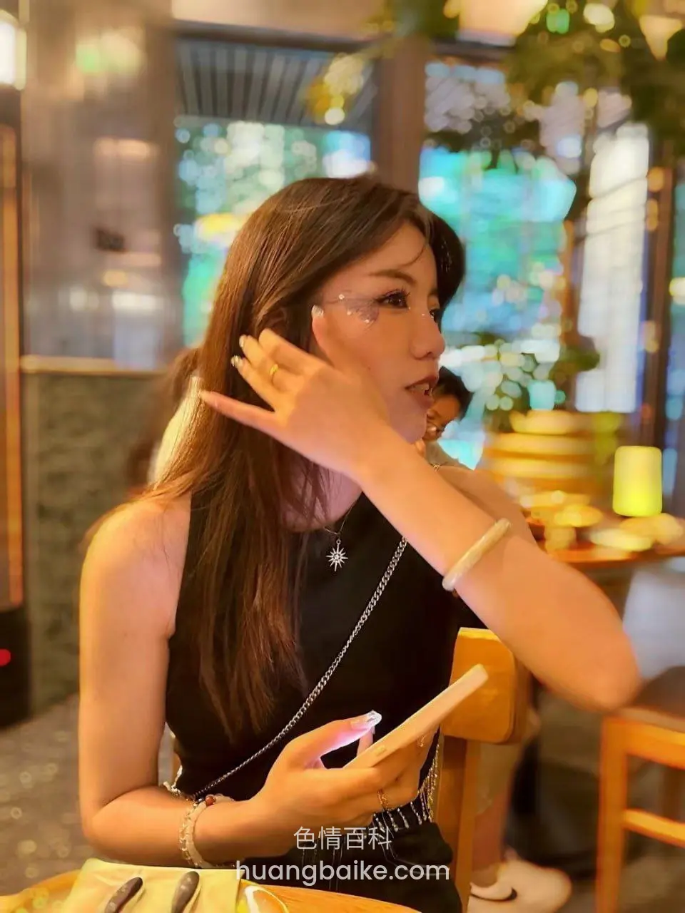 餐厅里侧脸举手比剪刀，拿着手机
