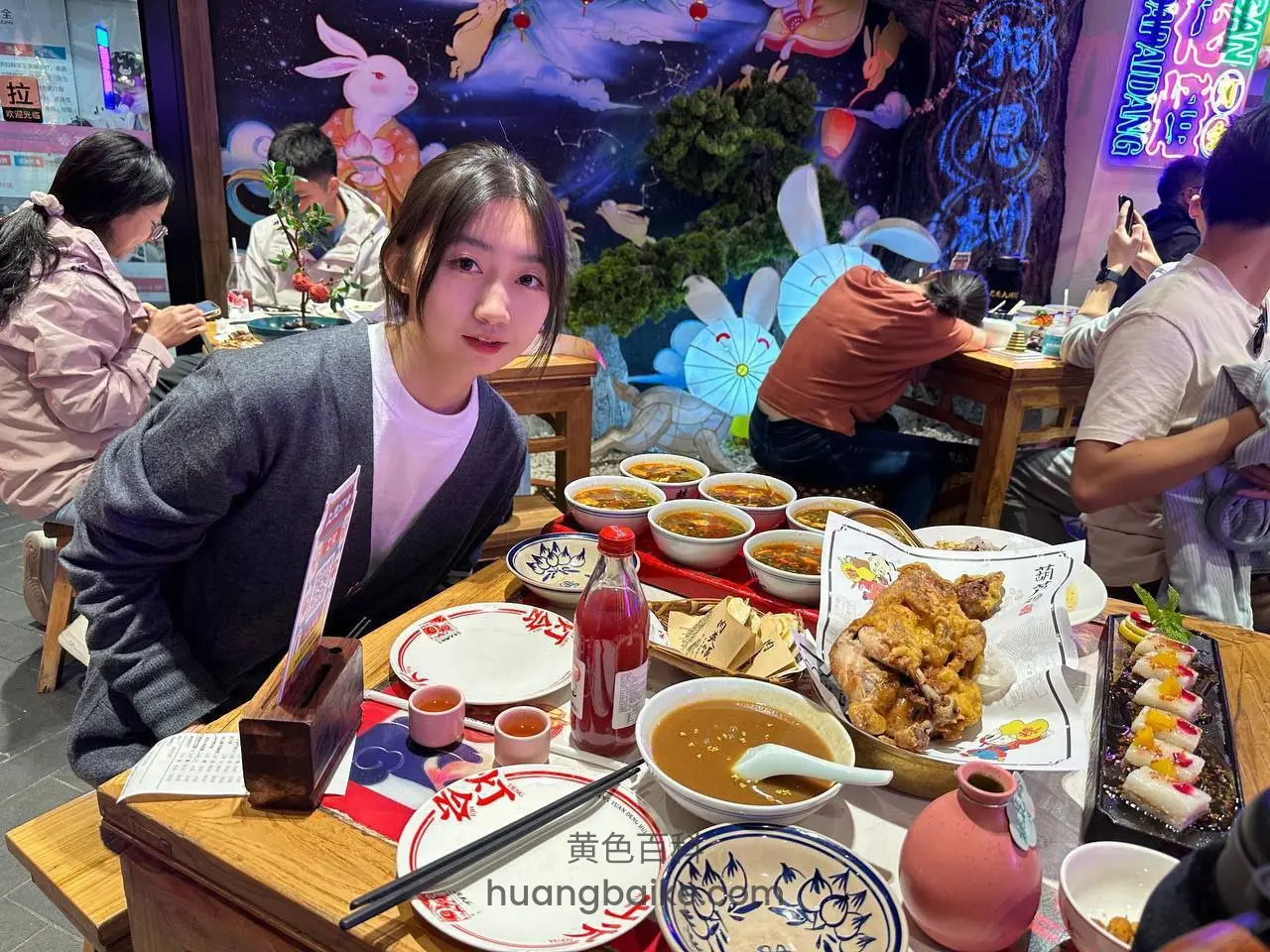餐厅餐桌前回头看镜头，桌上满是菜肴