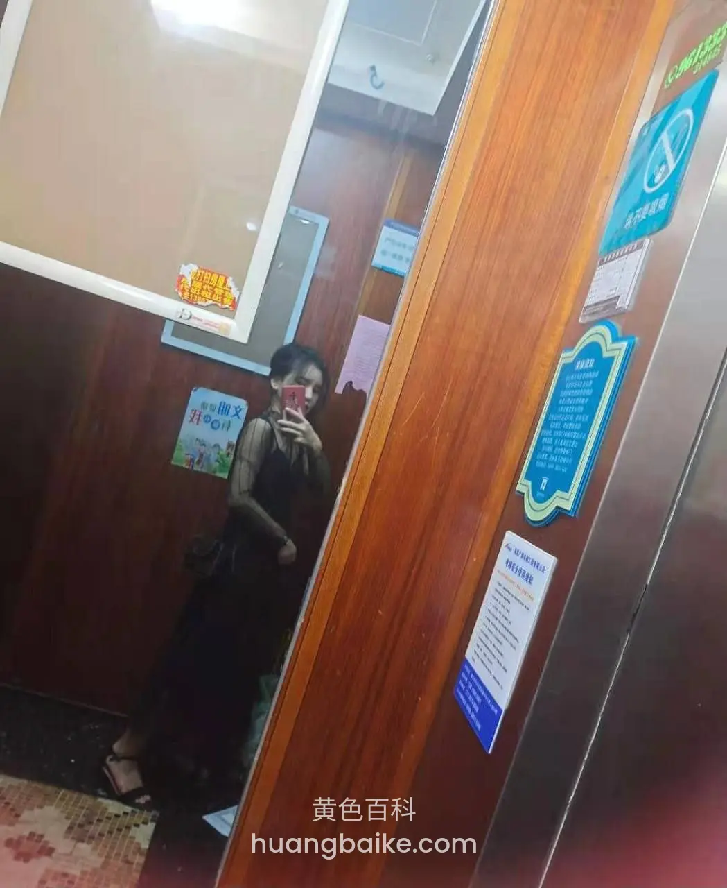 电梯间镜子前自拍，举着手机挡半张脸