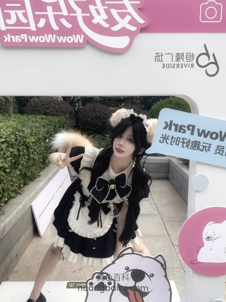 Wow Park门口站着比耶，身后广告牌
