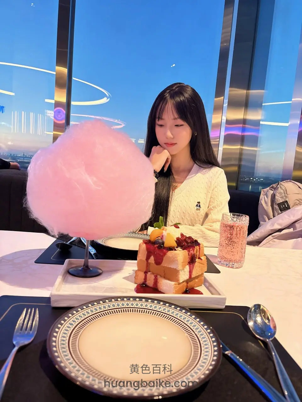 餐桌边托腮看镜头，旁边巨大粉色棉花糖和草莓吐司