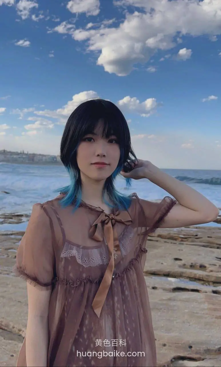 海边岩石上站着，右手摸头发