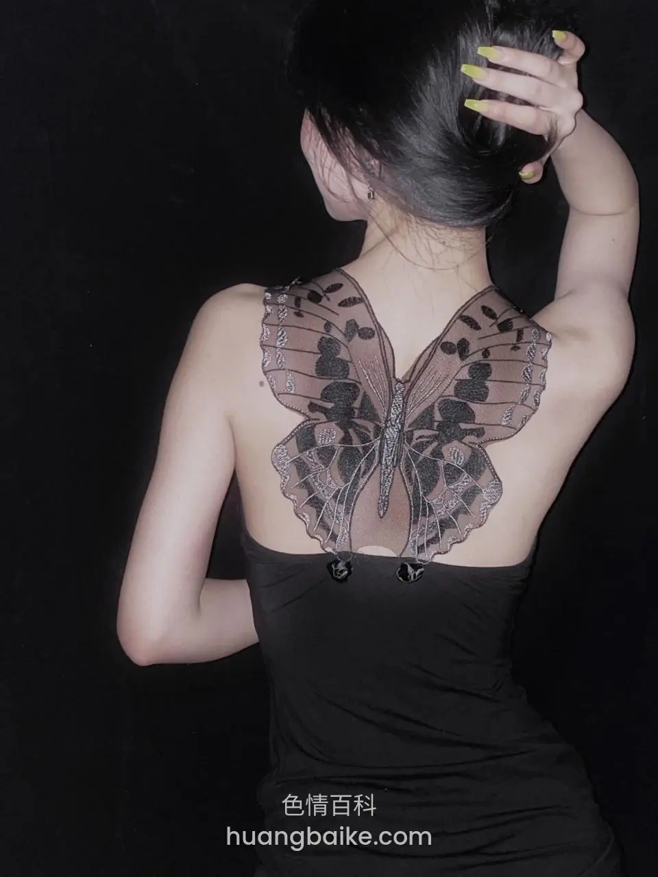 背对镜头手举过头顶，蝴蝶纹身占满后背