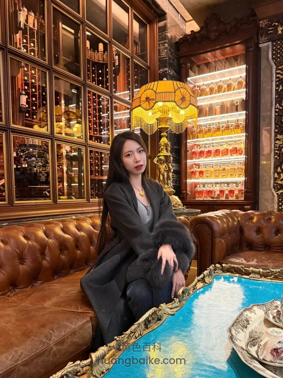 酒吧皮沙发坐着看镜头身后是酒柜