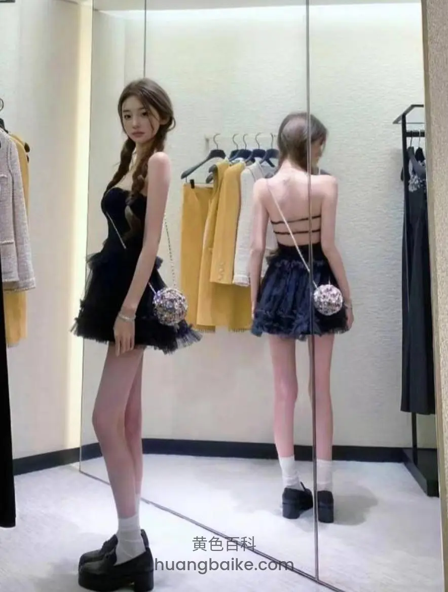 试衣间镜子前回头看，身后衣服架上挂着黄外套