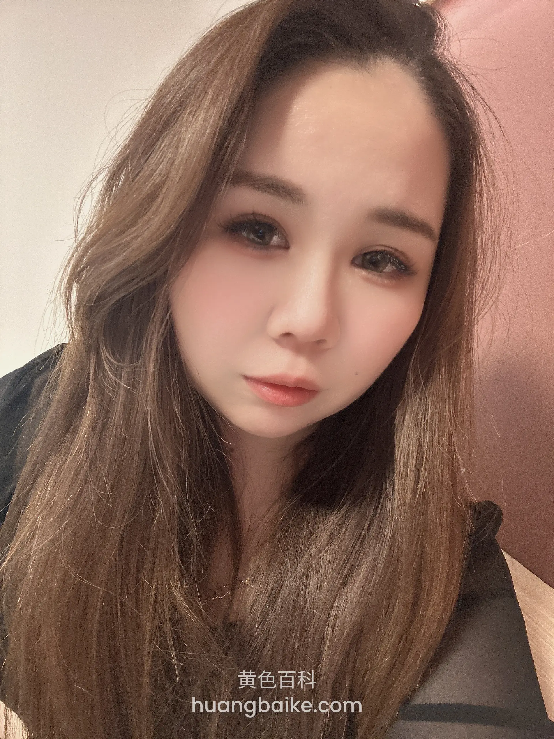 室内低头看镜头，身后粉墙