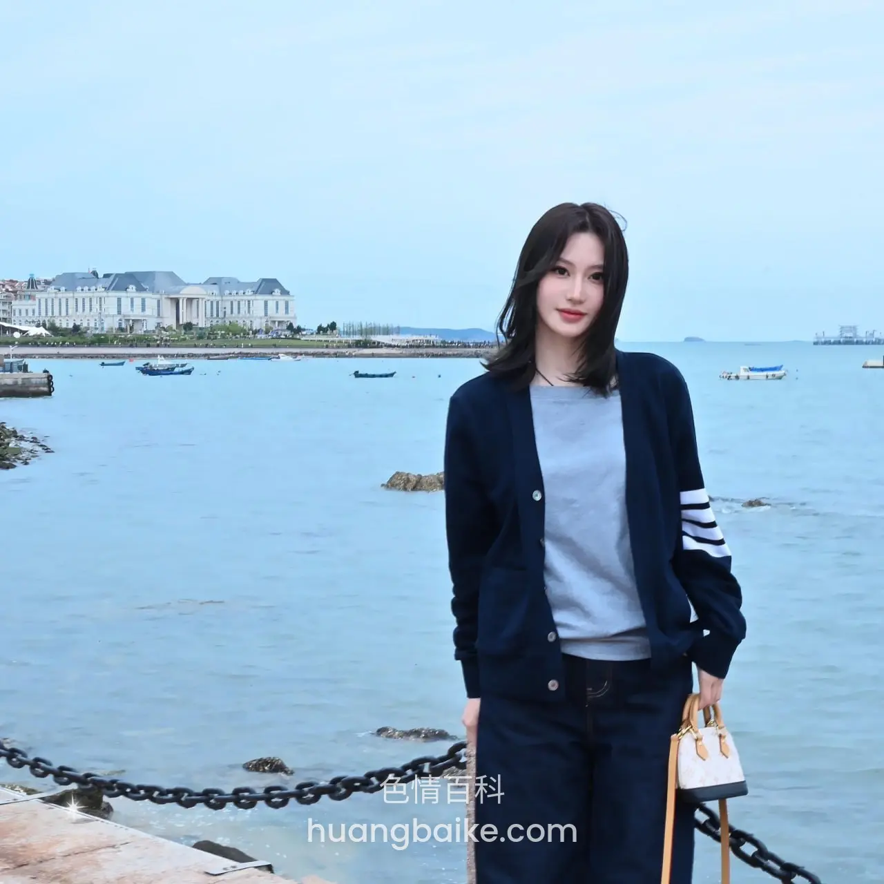 海边码头站着，手提白包望向远处
