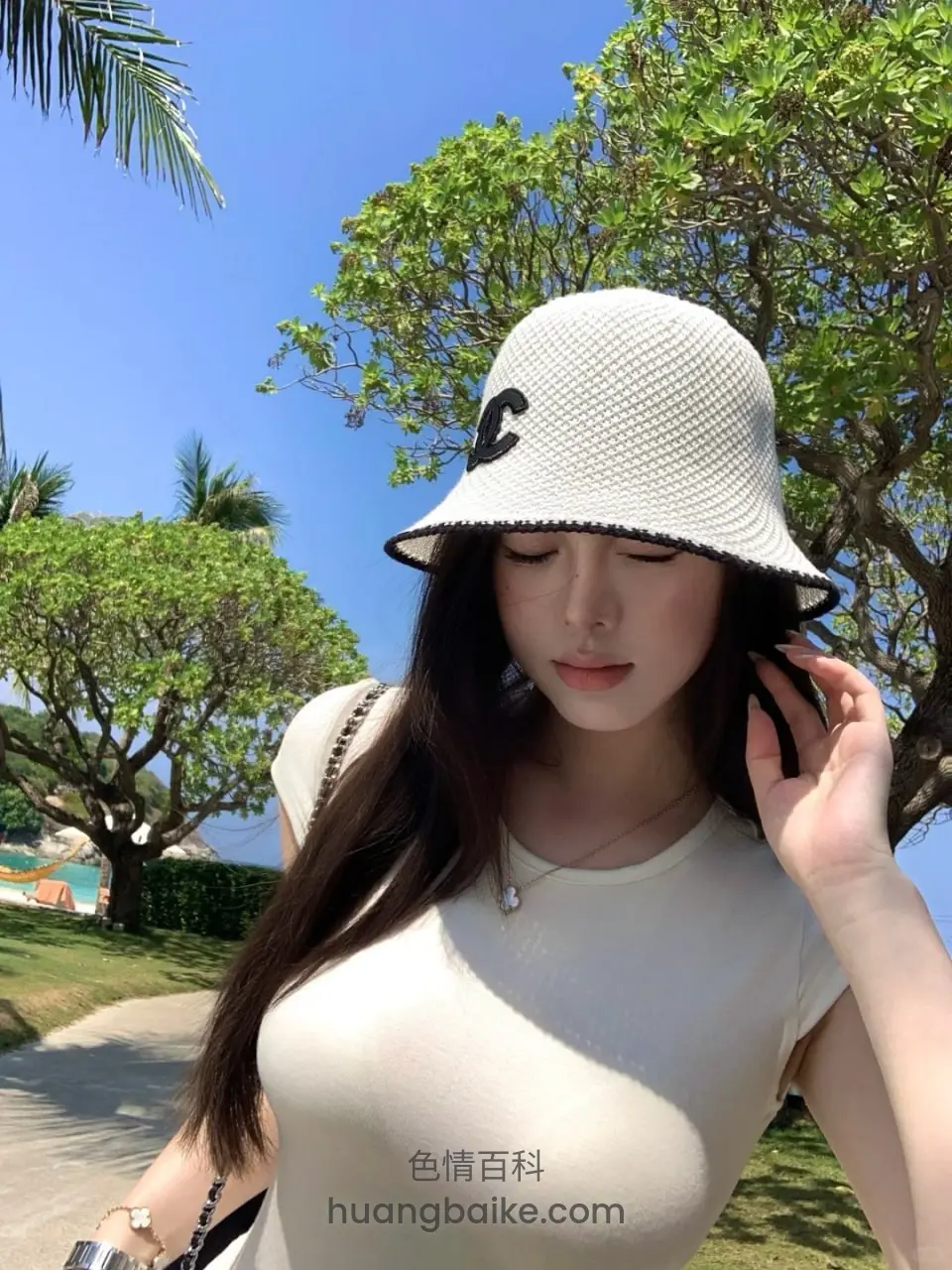 海边树下自拍，手扶着帽子