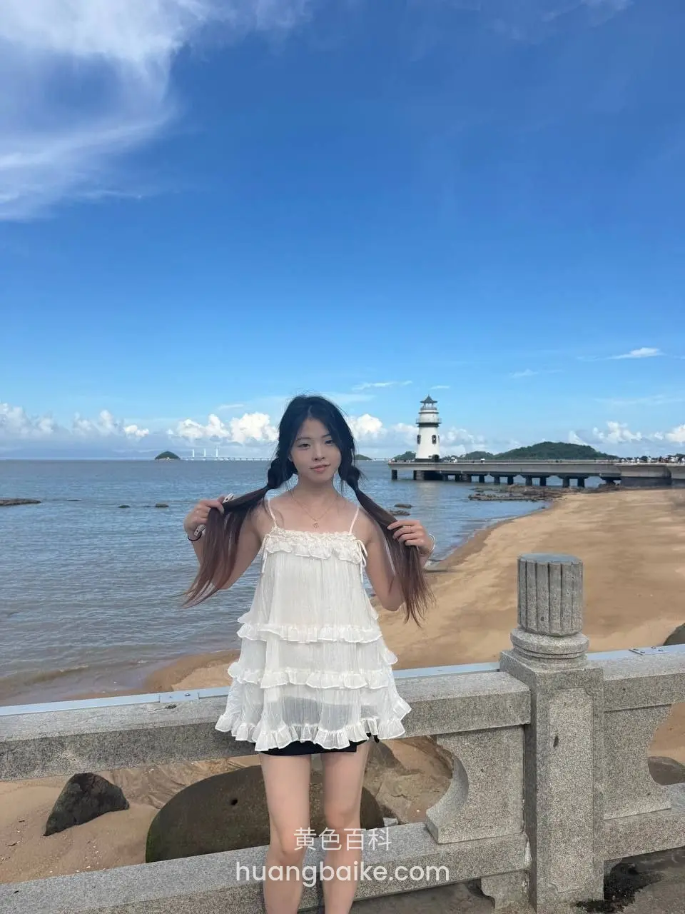 海边石栏杆前，双手抓着头发看镜头