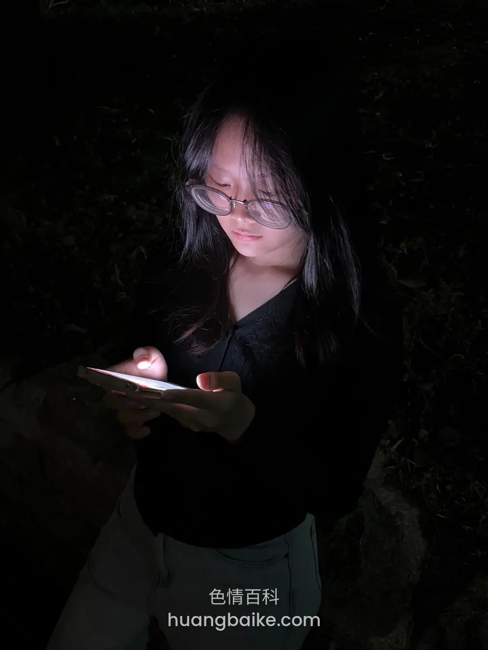 黑暗中拿着手机 屏幕照亮脸
