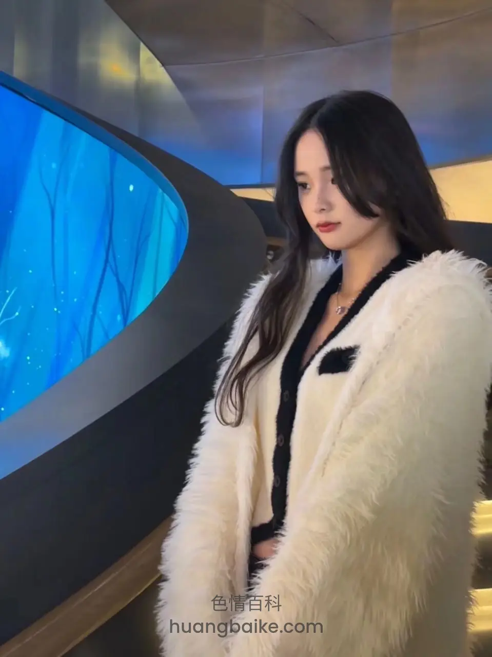 站在蓝色水族缸前侧身看镜头
