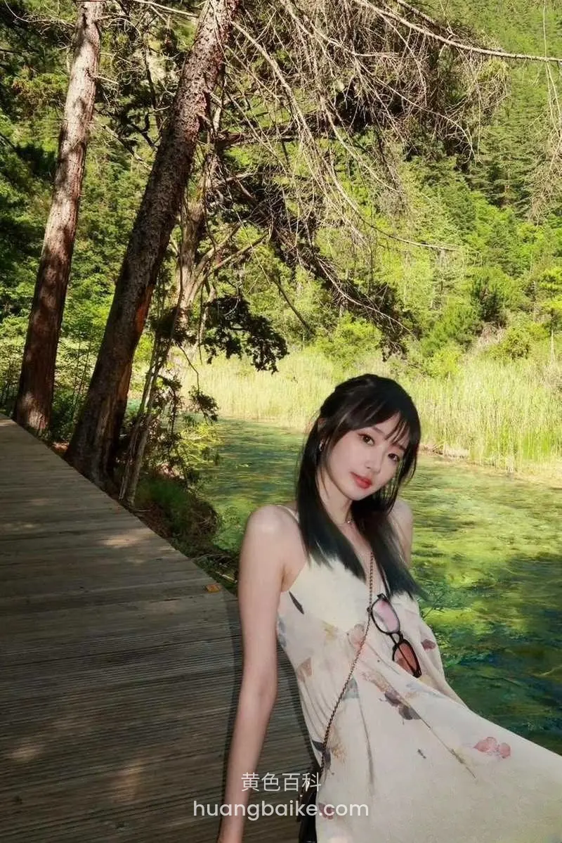 湖边木栈道上站立，身后是绿树和湖水