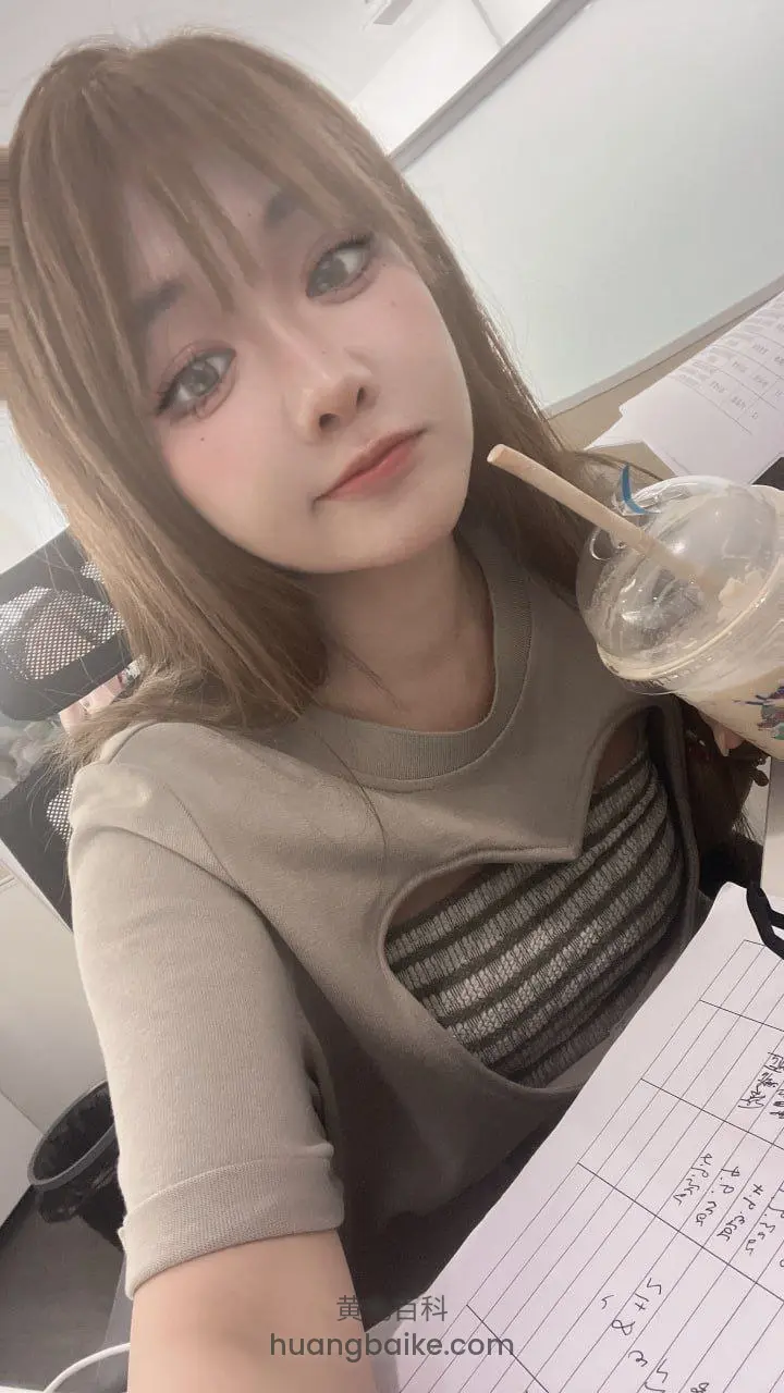 办公室桌上拿着饮料杯自拍