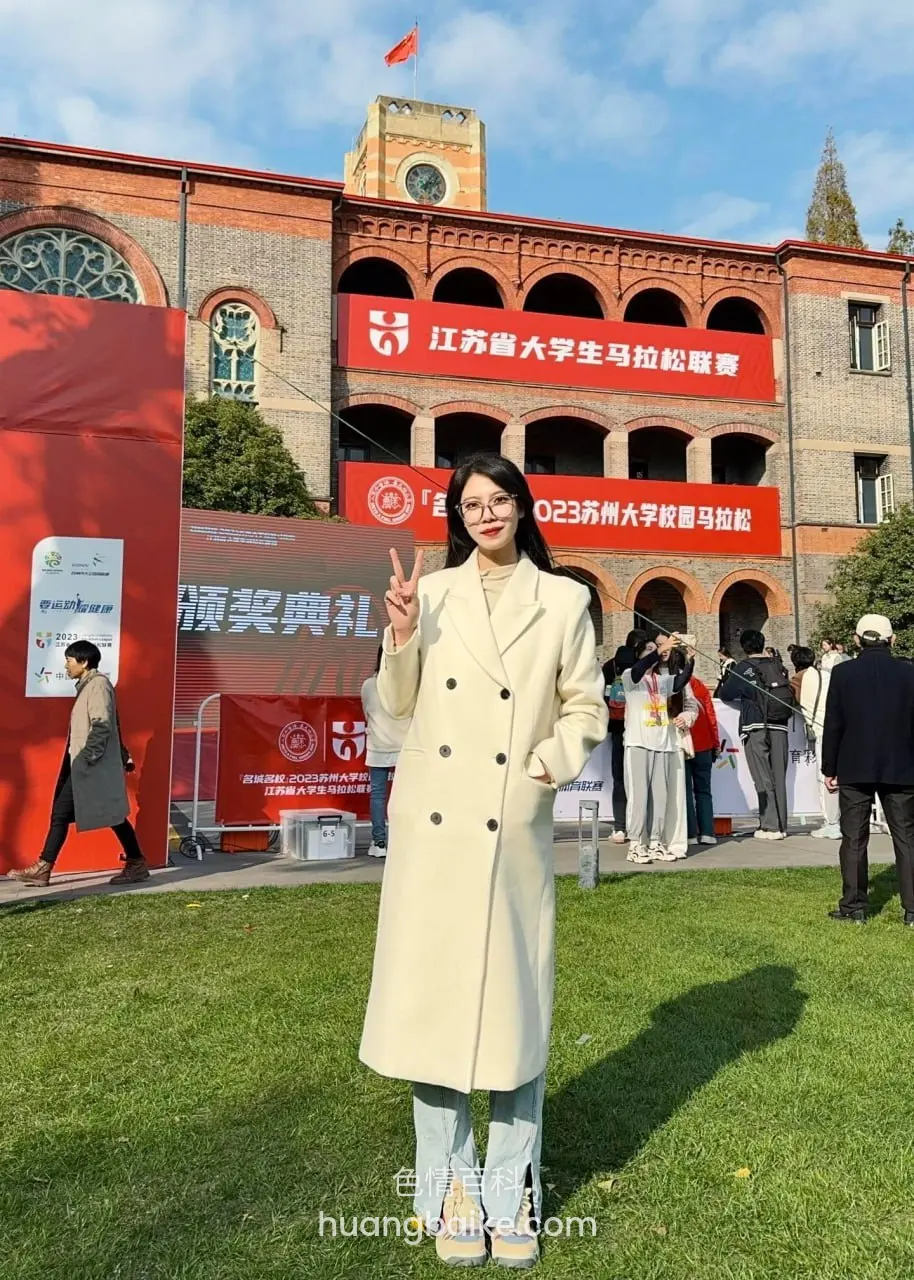 草坪上对着镜头比剪刀手，身后红楼和横幅