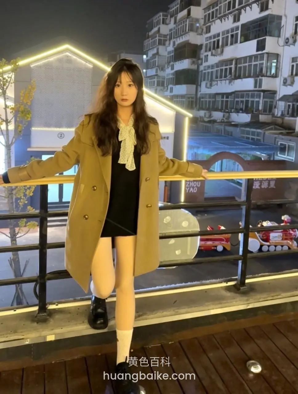 夜间栏杆边双手扶着