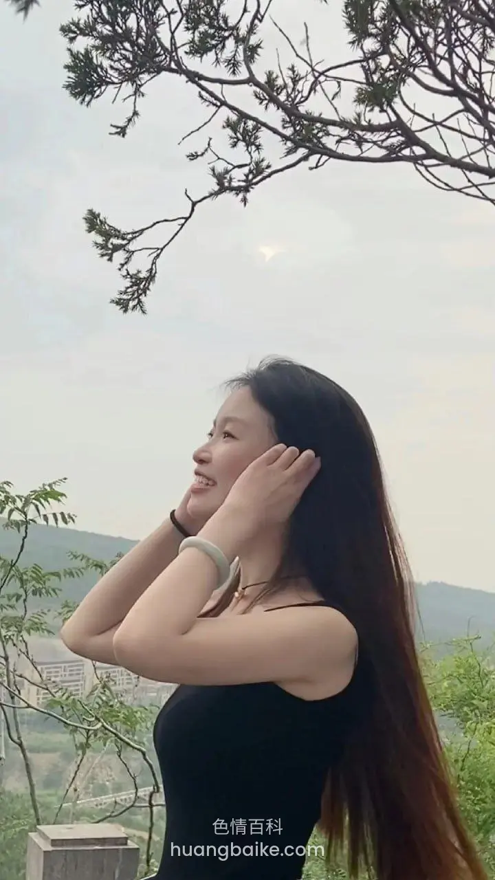 户外山边双手捧脸抬头看树枝
