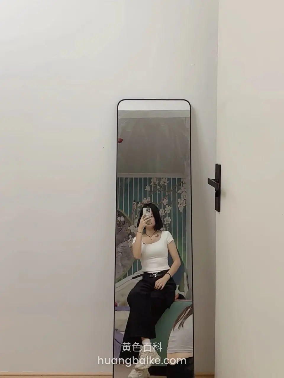 镜子前举手机自拍，黑裤白鞋坐在椅上