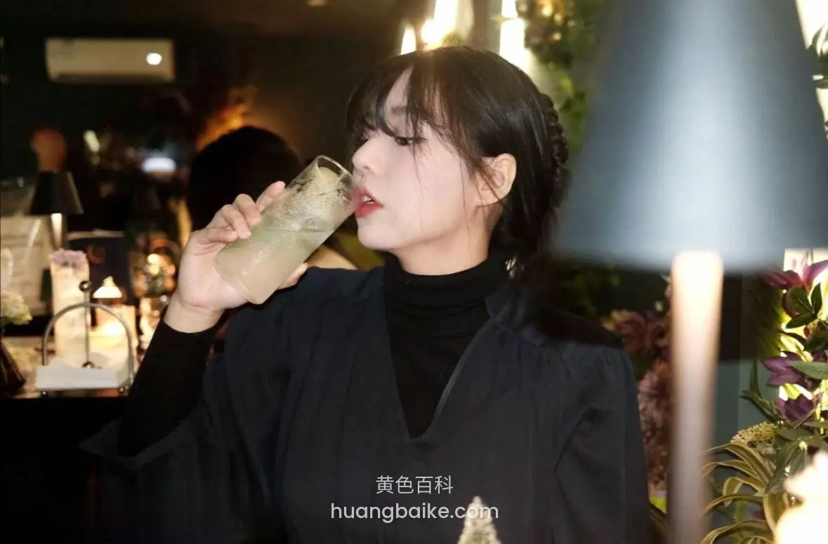 咖啡厅里喝饮料，拿着玻璃杯