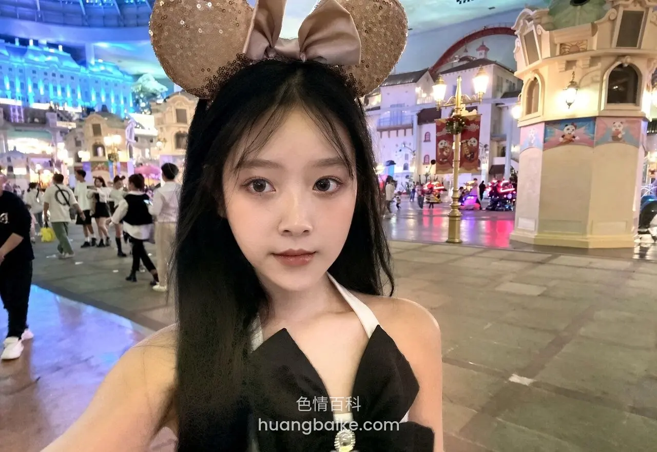 迪士尼米奇耳朵前自拍，身后城堡和人群
