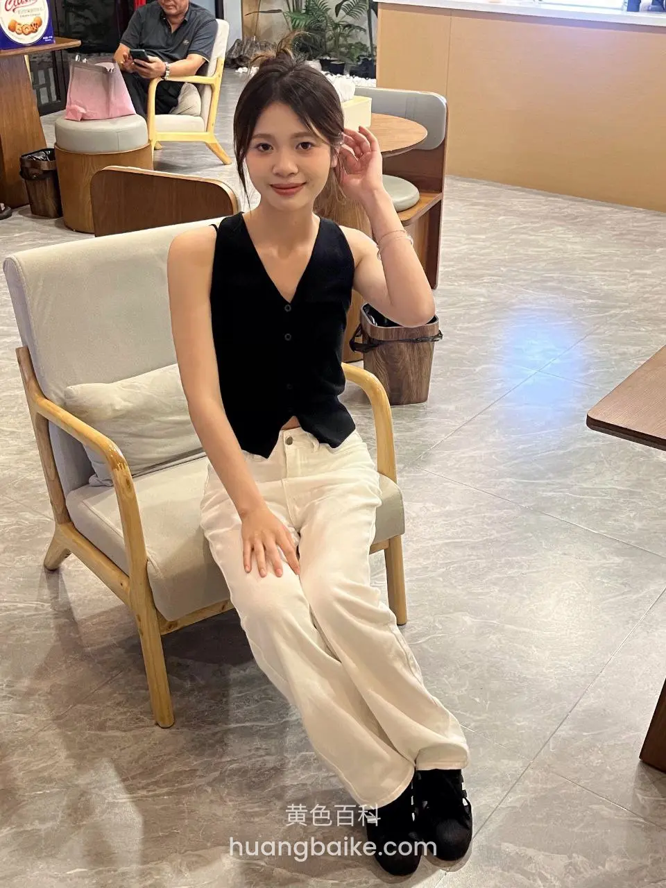 咖啡厅里坐椅子上，手指扶额，远处有人