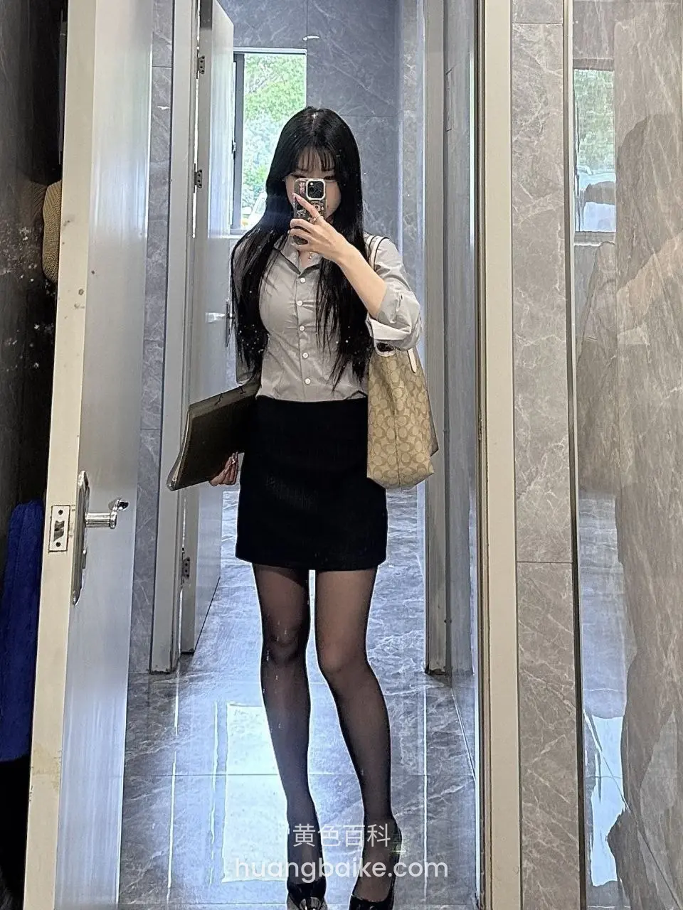 酒店走廊举手机自拍，身旁挎着包