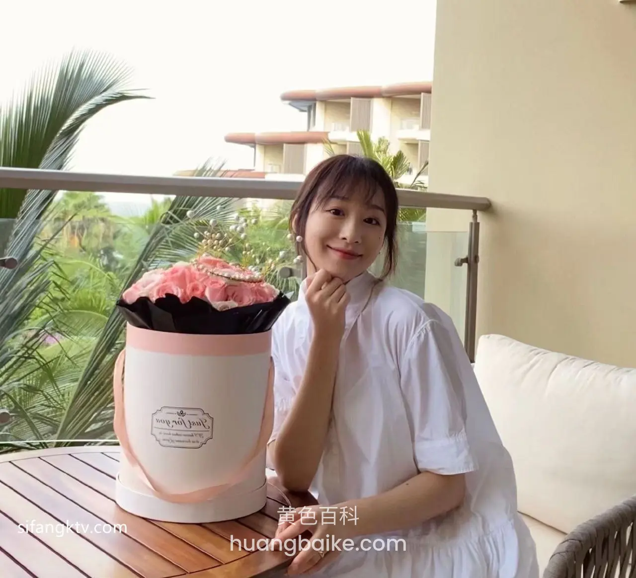 桌上粉玫瑰花盒，手托下巴看镜头