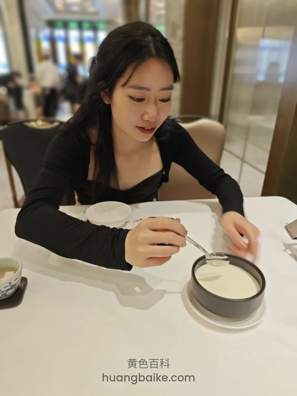 餐厅桌边拿着勺子舀奶酪蛋糕