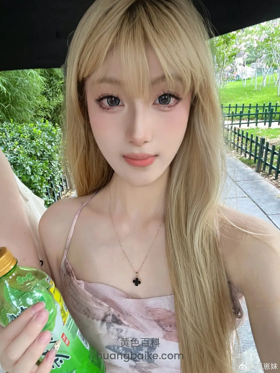 金发女孩户外自拍，手拿绿瓶饮料