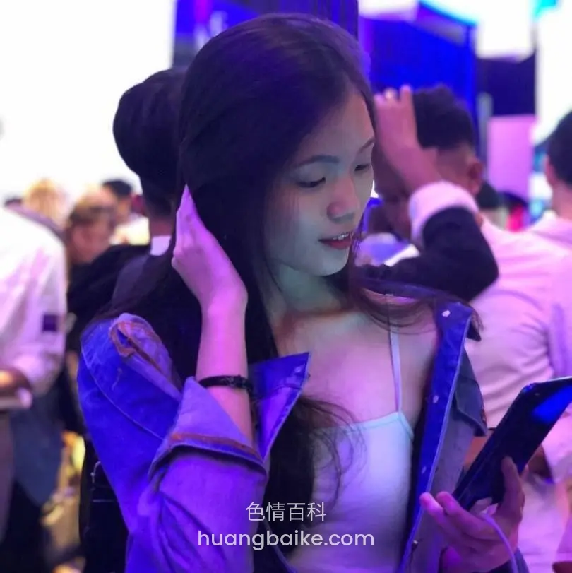 人群中低头看手机，手捂着耳朵