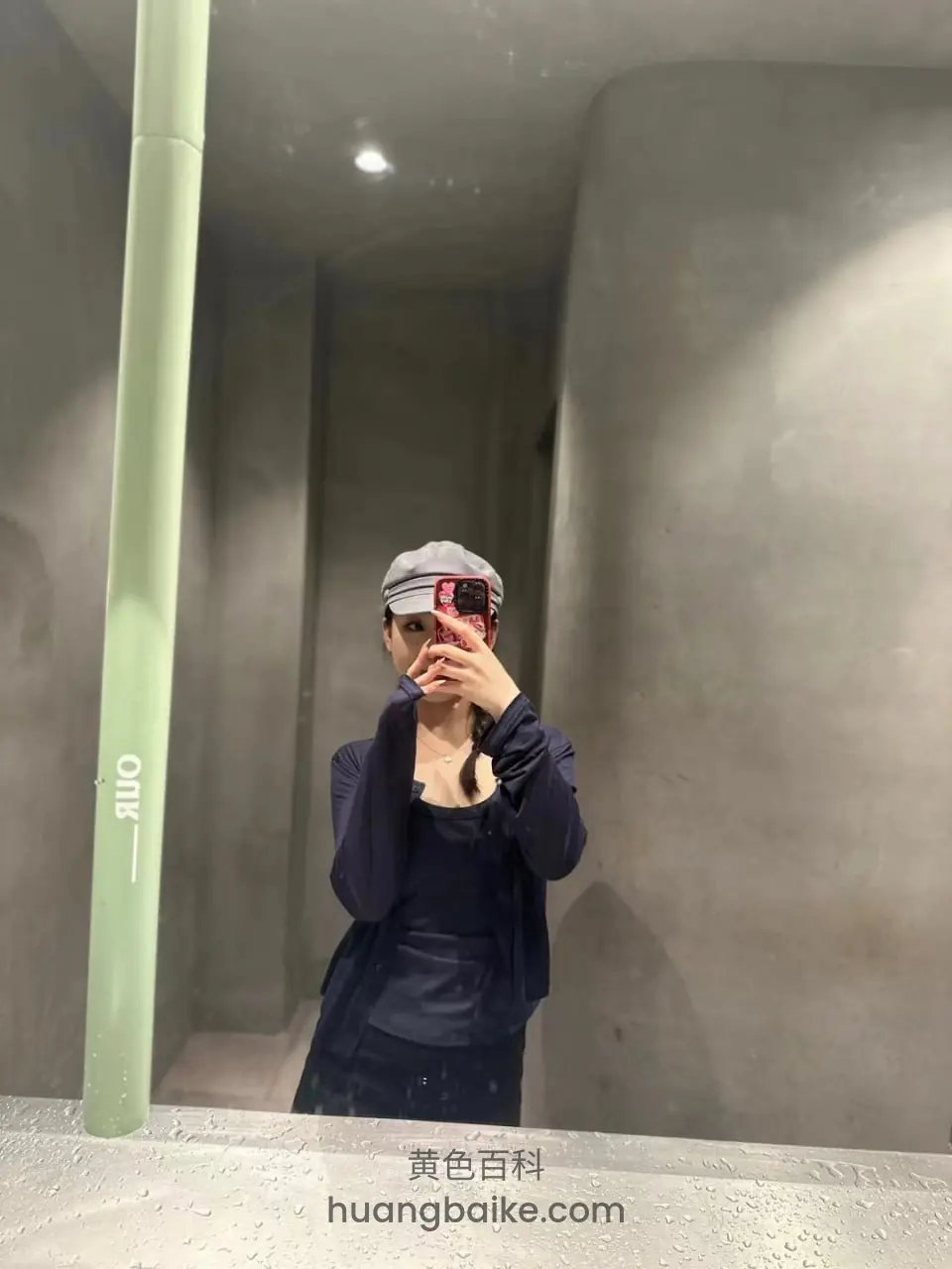 灰色混凝土空间里举手机拍镜子，镜头对着自己