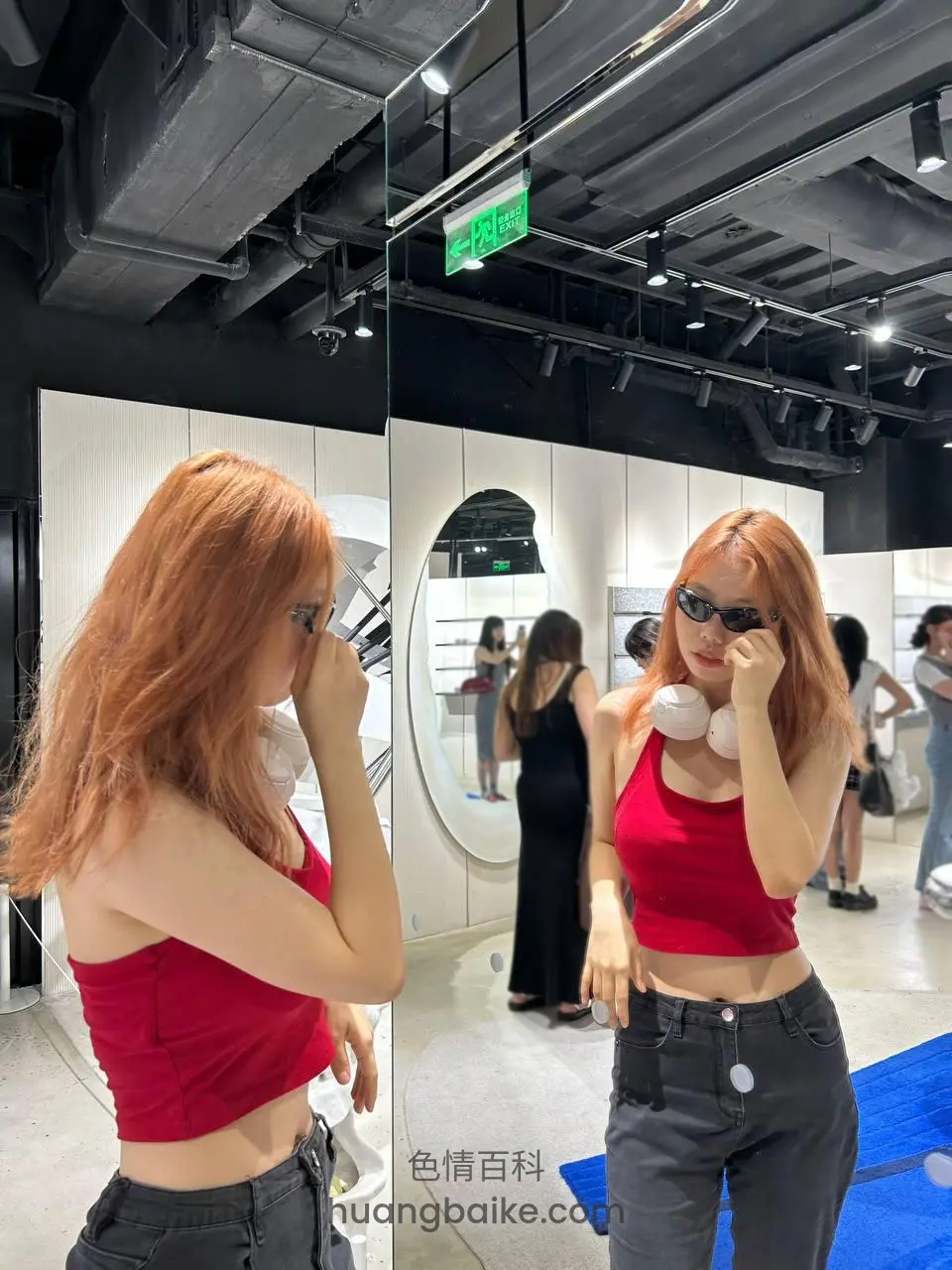 试衣间镜子前比剪刀手，头顶绿色的出口标识