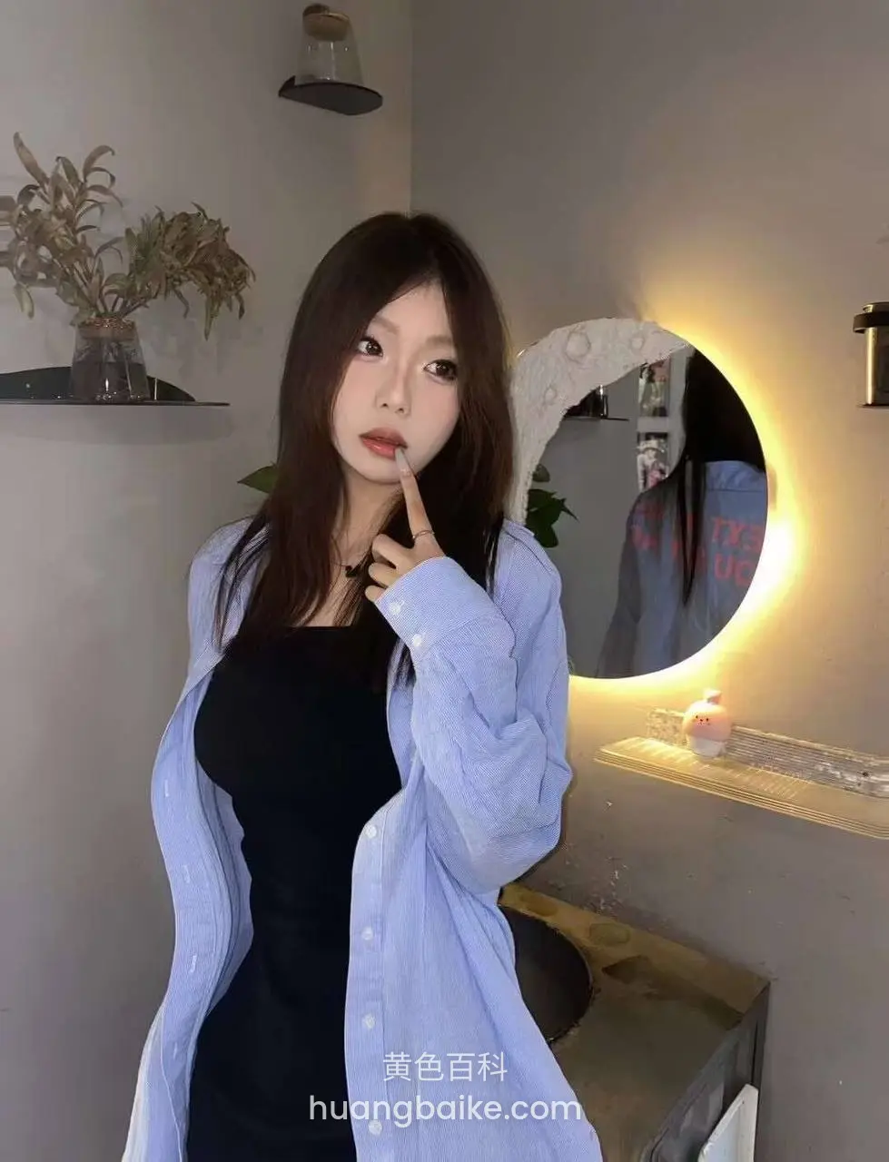 手指抵着嘴唇在镜子前站立