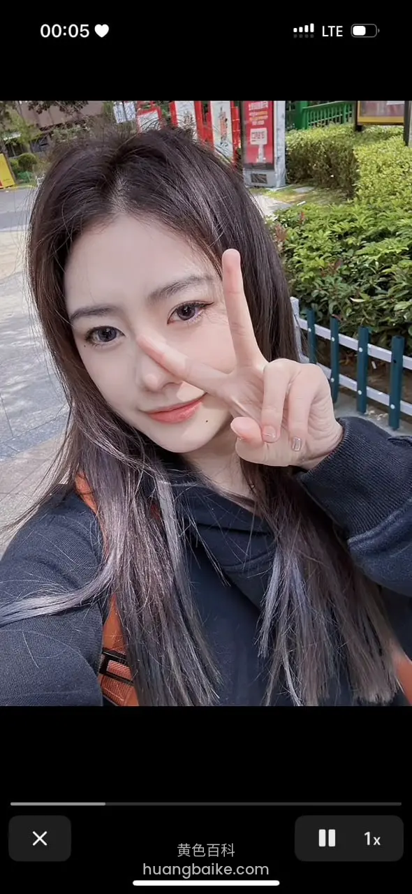 户外路边比剪刀手遮眼，手机界面时间00:05